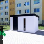 Panelák v pozadí bieleho záhradného domčeka