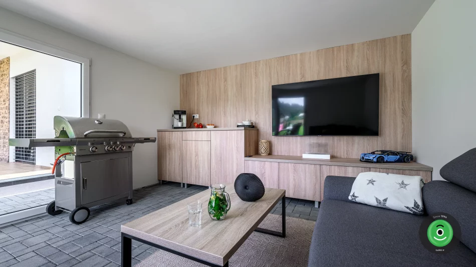 Interiér tiny house GARDEON s gaučom, grilom a TV