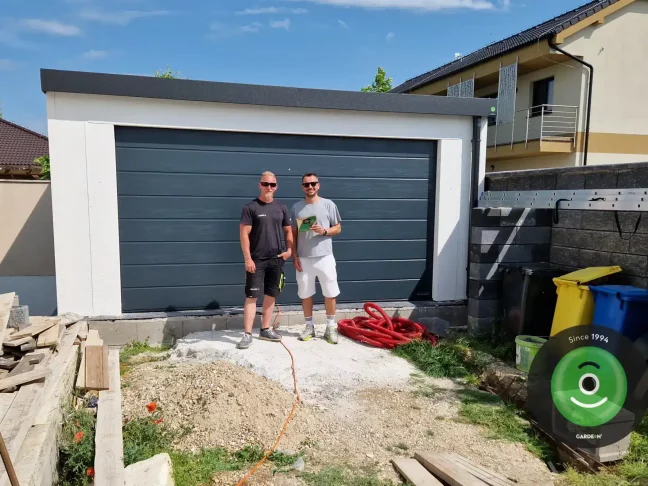 Spokojený zákazník s montážníkem před garáží
