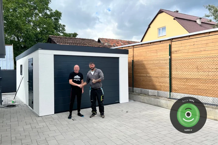 Elégedett ügyfél a szerelővel a garázs előt