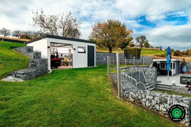 Nyitott garázs bent tárolt szerszámokkal és kerti gépekkel