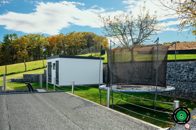 Oldalnézet a garázsról trambulinnal és gabionfallal