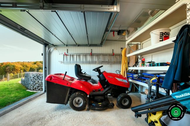 Részlet a garázsról polcokkal szerszámokkal és piros fűnyíróval