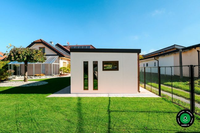 Tágas garázs integrált előtetővel családi ház mellett