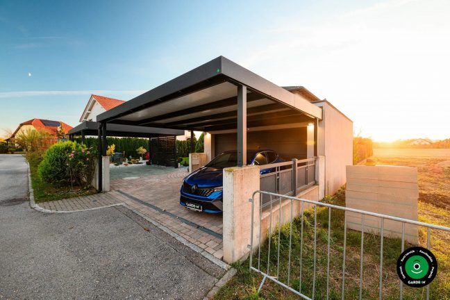 Tágas garázs előtetővel térkövezéssel és kilátással a rendezett kertre