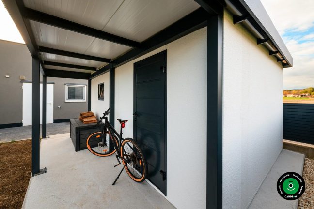 Előtető a garázs mellett falnak támasztott kerékpárral