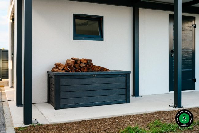 Fa tárolódoboz elhelyezett tűzifával az előtető alatt