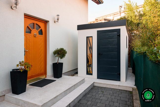 Kerti házikó a családi ház narancssárga ajtajai mellett