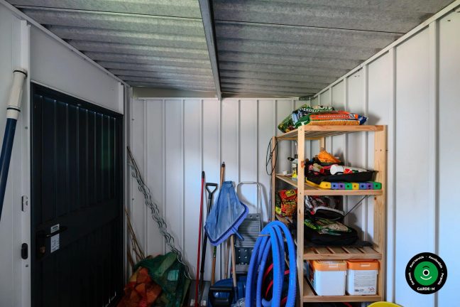 A kompakt házikó beltere rendezett kerti eszközökkel