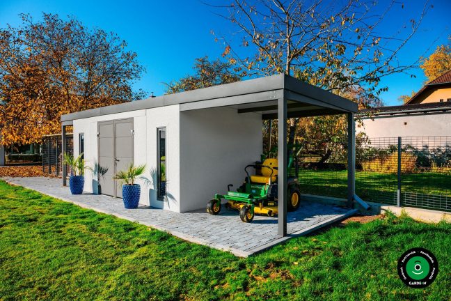 Praktikus szerelt házikó beton járdával és zöld háttérrel