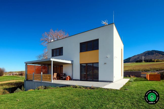 Pergola ülőrésszel a teraszon családi ház mellett