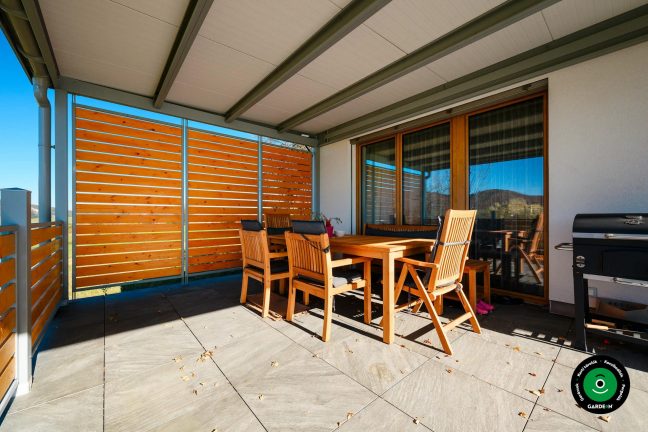 Tágas pergola kényelmes ülőrésszel családi ház mellett