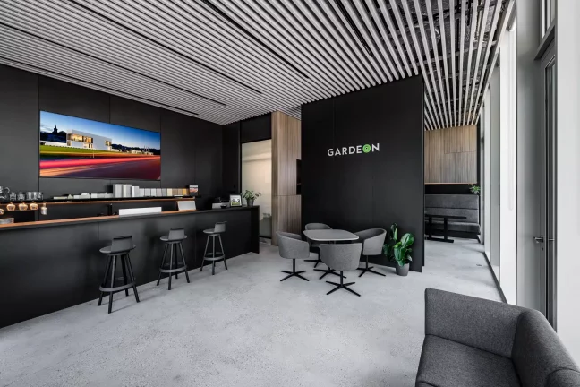 Modern GARDEON showroom fekete fallal, bárpulttal és lamellás mennyezettel
