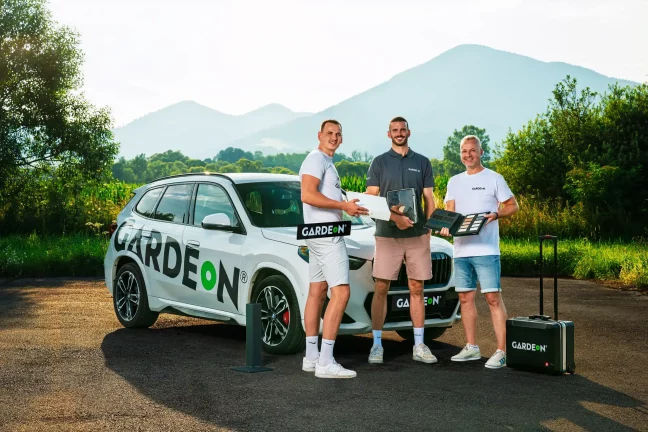 Három GARDEON ügynök anyagokkal és táskával a cég BMW-jénél.