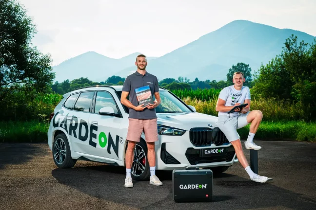 Két GARDEON munkatárs mintakönyvvel és tablettel a BMW előtt.