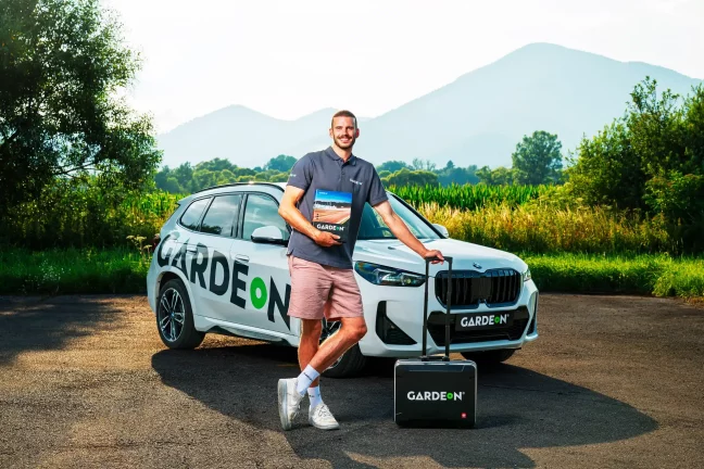 GARDEON munkatárs mintakönyvvel és táskával a BMW előtt természetben.