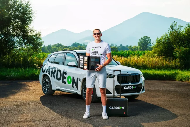 Ügynök vakolat-mintakönyvet tart a BMW előtt természeti környezetben.