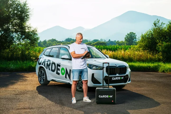 GARDEON ügynök tablettel, cég BMW-vel és táskával természetben.