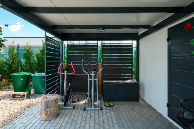 Fitneszzóna antracit kocsibeálló alatt fém lamellás oldalfalakkal.