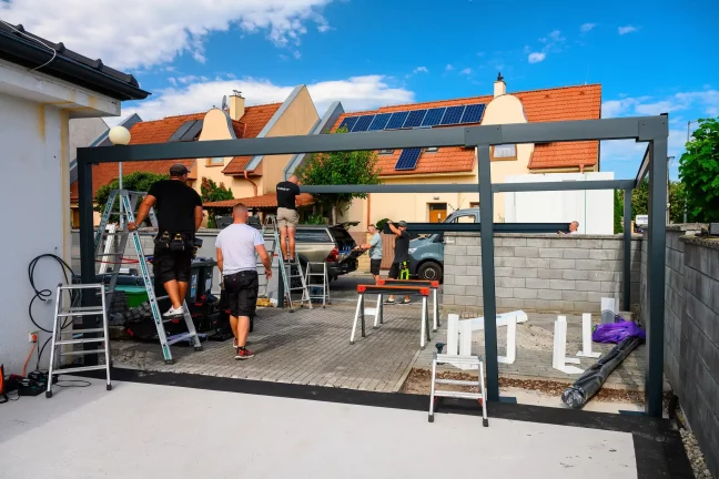 A szerelők az előtető acélszerkezetét építik az utca mellett
