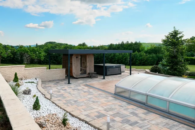 Pergola a medencénél fedéllel, dekoratív kövekkel és dísznövényekkel