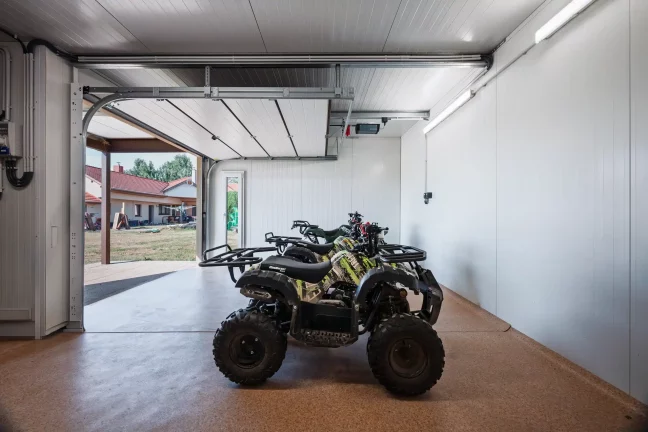 Több quad parkol a kerti ház belsejében elektromos panellel
