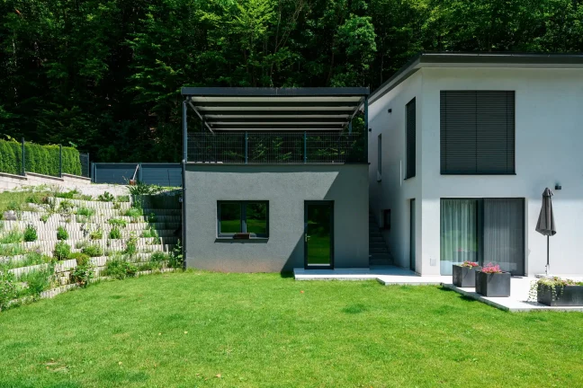 Antracit pergola lapostetővel emelt alapon elhelyezve.