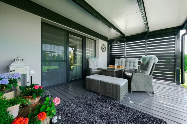 Antracit pergola fémlamellákkal és rattan ülőbútorral a teraszon.